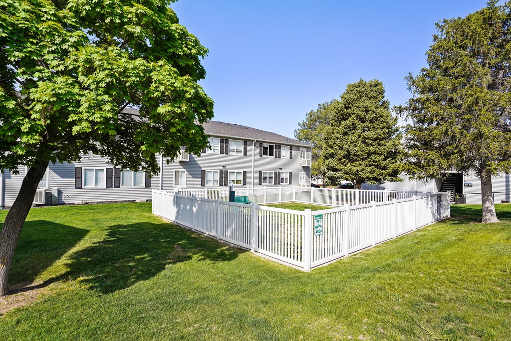 the backyard of a house with a white fence