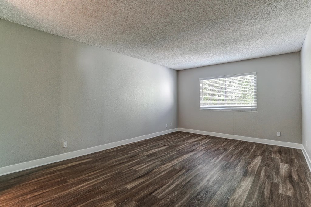an empty living room with wood flooring and a window at Aspire Upland Apartments, Upland, CA, 91786