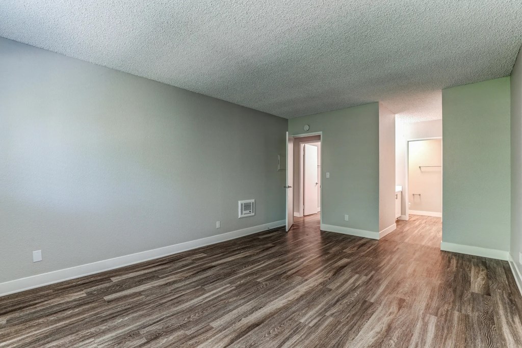 an empty living room with wood flooring and green walls at Aspire Upland Apartments, Upland, CA