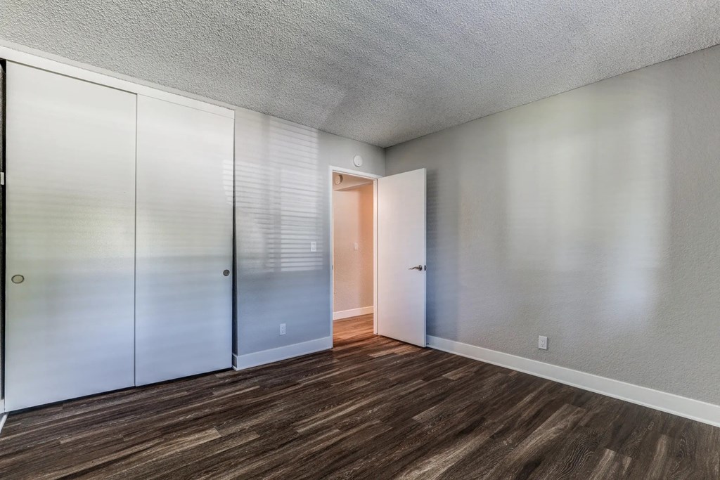 a bedroom with white cabinets and a door to a closet at Aspire Upland Apartments, Upland, CA