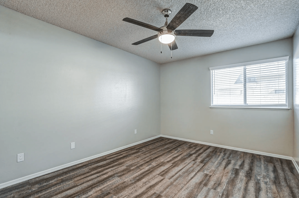 an empty living room with a ceiling fan and a windowat Aspire Seneca, Victorville, CA
