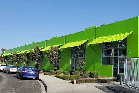 a large green building with cars parked in front of it