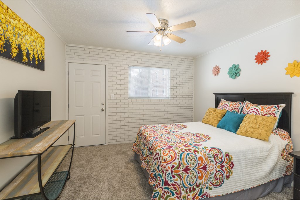 a bedroom with a bed and a ceiling fan