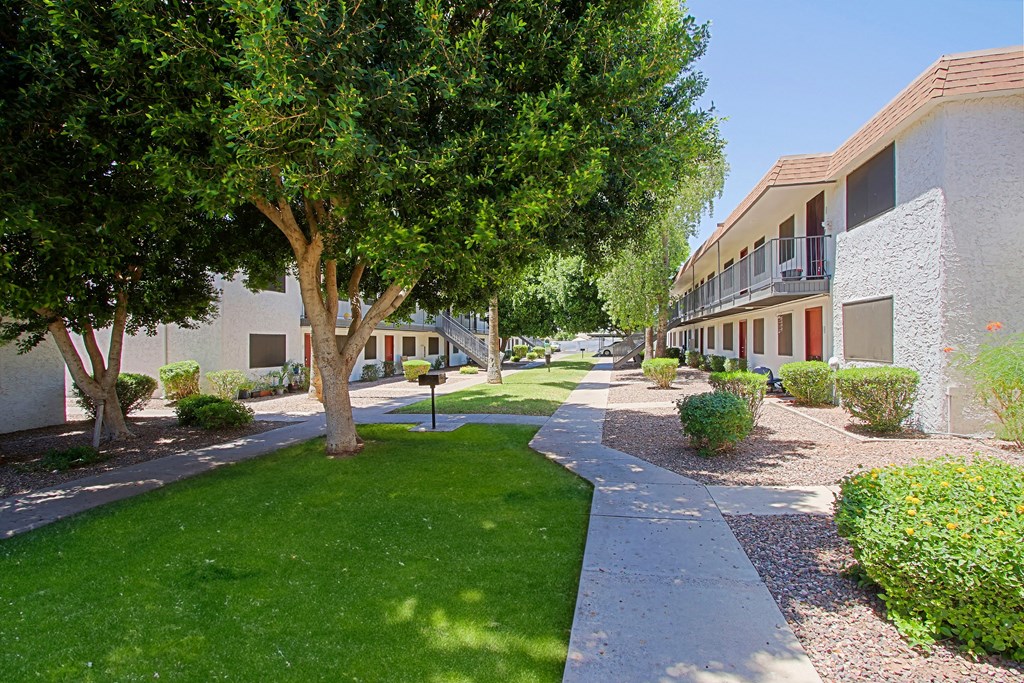 a walkway between two buildings at the whispering winds apartments in pearland, tx