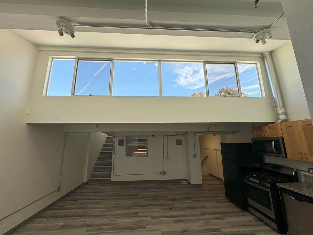 an overhead view of a living room with a staircase and windows