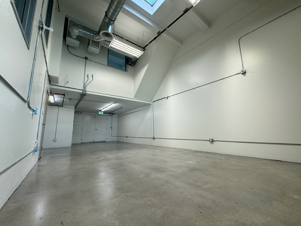 a large room with a concrete floor and white walls