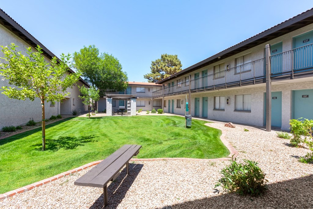 a courtyard with a picnic table and a bench