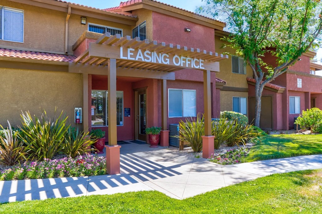 a building with a leasing office and a tree in front of it at The Arches at Regional Center West Apartments, Palmdale, 93551