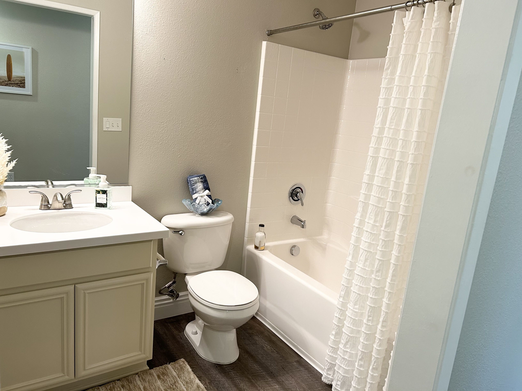 a bathroom with a bathtub toilet and sink at Riverton of the High Desert Apartments,Victorville, CA