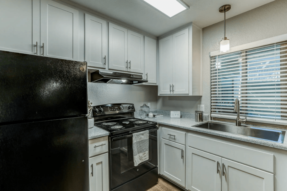  Kitchen with Black Appliances, Grey Cabinets, and Wood-Style Flooring at Aspire Upland Apartments, Upland
