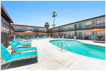 A pool surrounded by sun loungers and umbrellas.