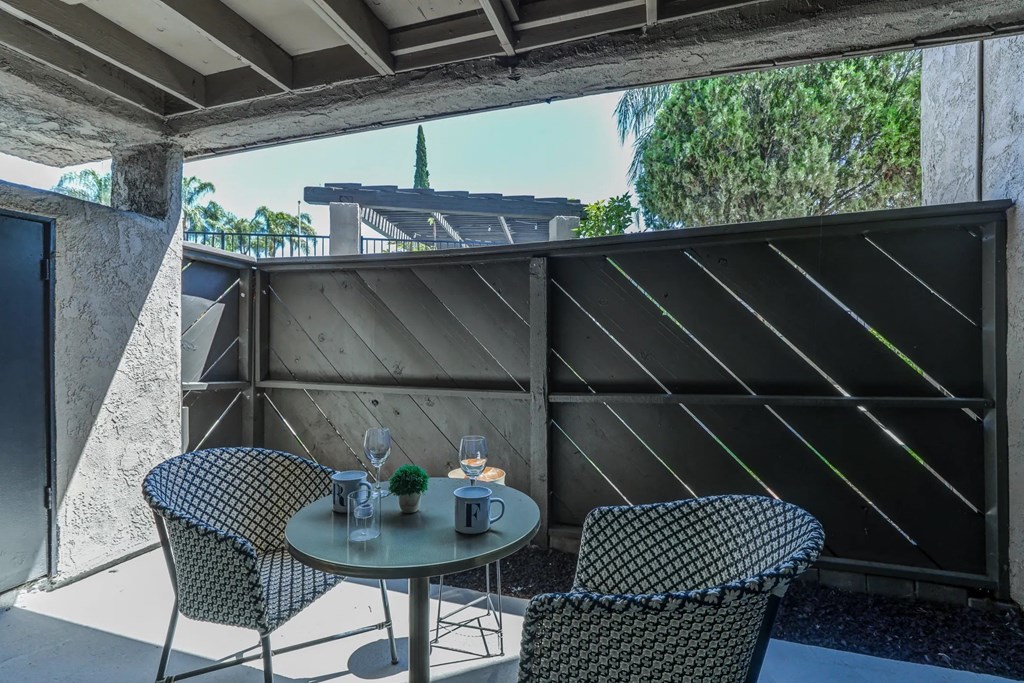 a patio with a table and chairs on a balcony at Aspire Upland Apartments, California