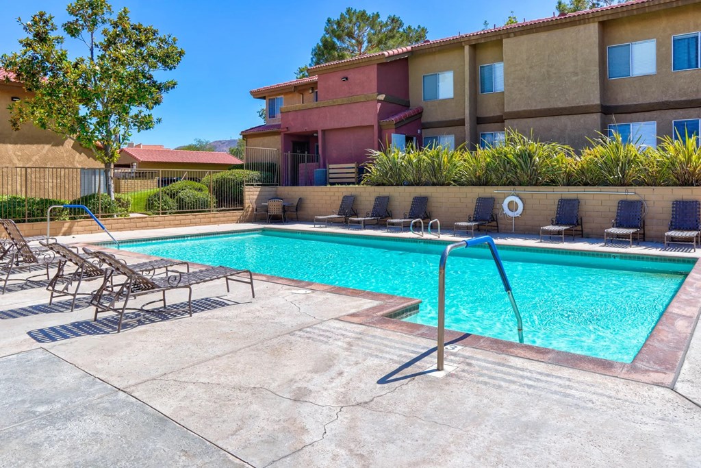our apartments have a swimming pool with chairs at The Arches at Regional Center West Apartments, Palmdale