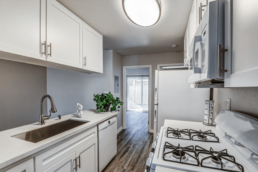 a kitchen with white cabinets and a sink and a stove at Aspire Seneca, Victorville