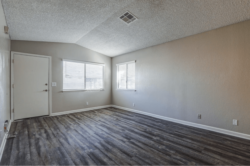 the living room of an empty home with wood flooring and a door and windowat Aspire Seneca at Aspire Seneca, Victorville, California