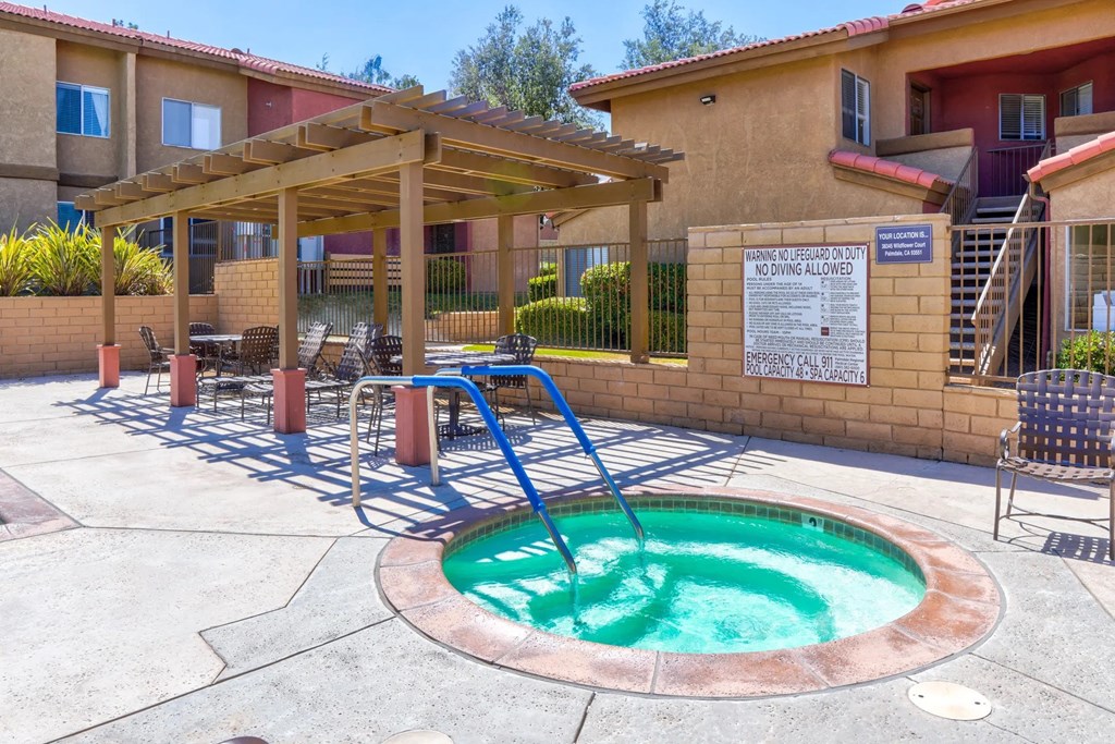a hot tub in a patio with a pool at The Arches at Regional Center West Apartments, Palmdale, CA
