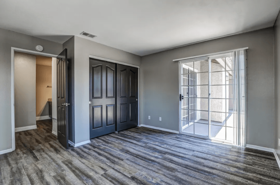 the living room of a new home with doors and a window at Vista Promenade Apartments, Temecula