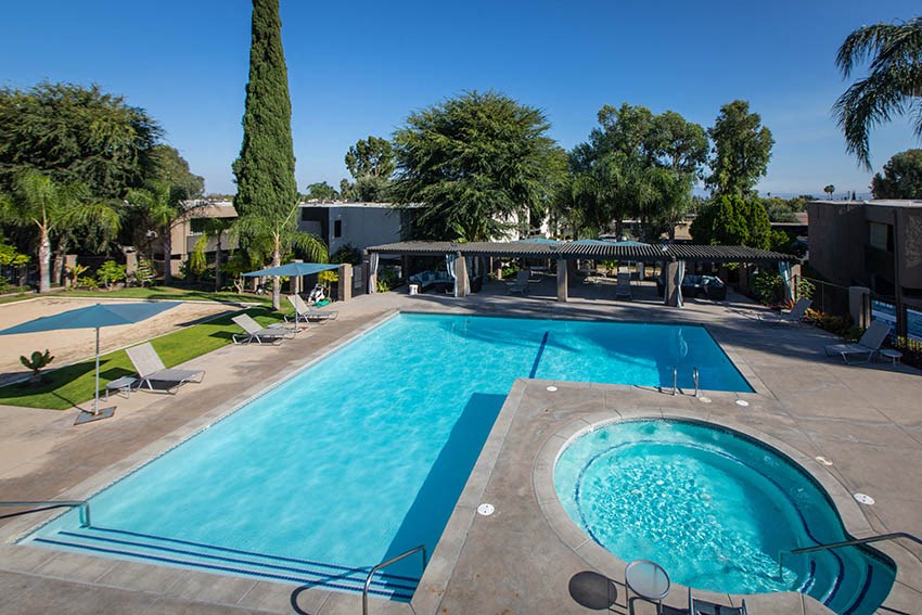 Sparkling Pool and Spa Surrounded By Lounge Seating, Umbrellas, and Greenery at Aspire Upland Apartments, Upland, 91786