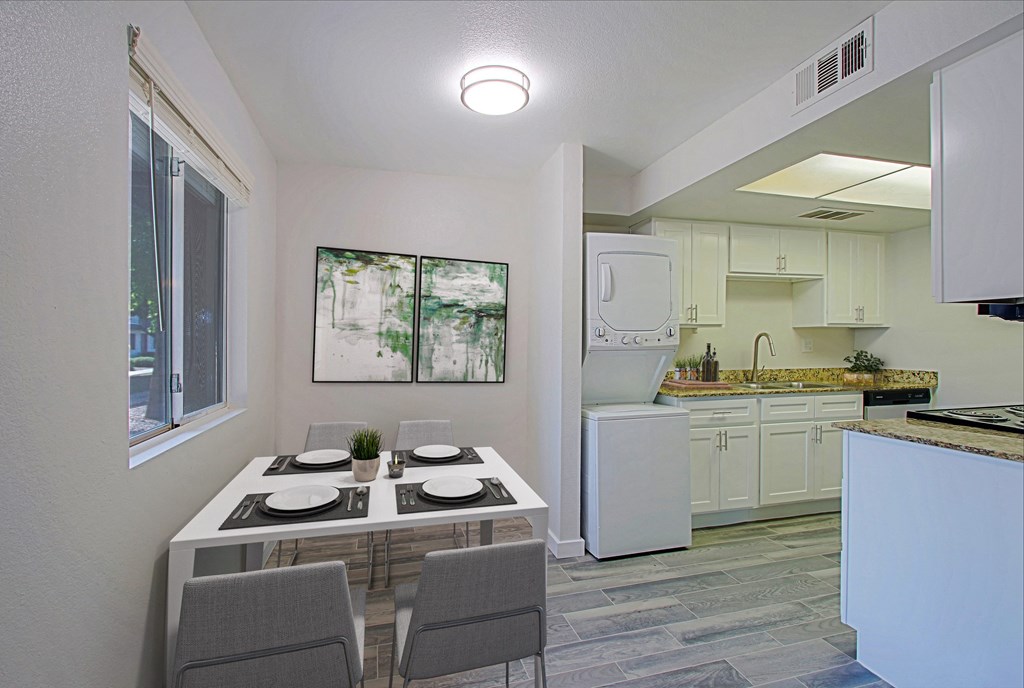 a kitchen and dining room with white appliances and a table and chairs