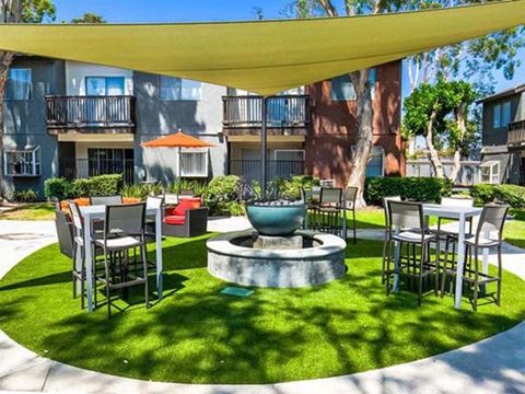 Ontario Apartments for Rent - Encore - Outdoor Lounge with Yellow Shade Cover, Chairs, and Water Feature