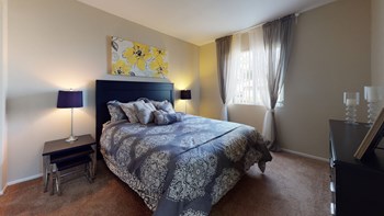 Apartments for Rent in Victorville CA - Aspire of the High Desert - Spacious Carpeted Bedroom with Window for Natural Light and Modern Furnishings - Photo Gallery 4