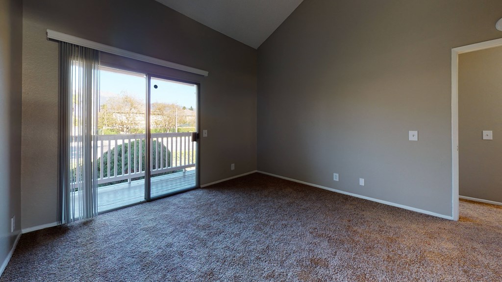 Two Bedroom Apartments in Ontario CA - Rancho Vista - Unfurnished Bedroom With Lush Carpet, a Sliding Glass Door With Shutters, and Balcony Access at Rancho Vista Townhomes, Ontario
