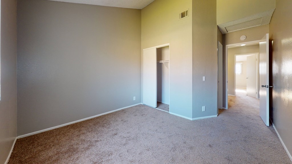 Ontario CA Apartments for Rent - Rancho Vista - Unfurnished Bedroom With Lush Carpet Flooring, a Closet, and Natural Lighting From the Window at Rancho Vista Townhomes, Ontario, CA