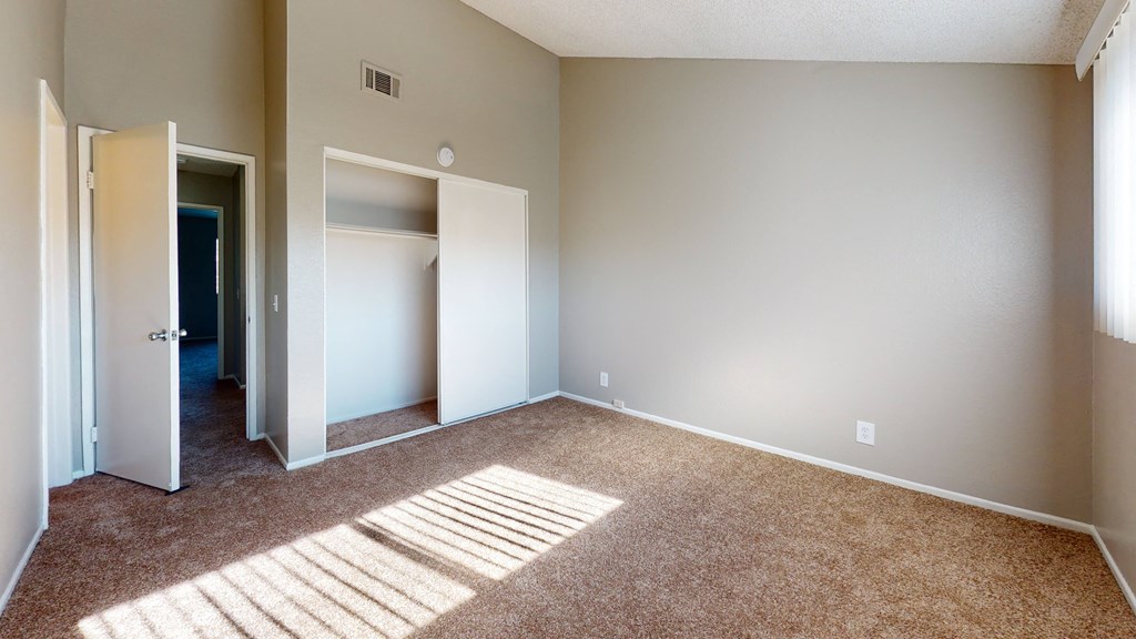 Apartments for Rent Ontario - Rancho Vista - Unfurnished Bedroom With a Spacious Closet, Carpet Flooring, and a Window With Shutters at Rancho Vista Townhomes, Ontario, CA, 91764