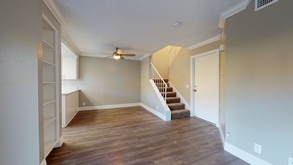 Unfurnished Entryway With Nearby Dining Area, Living Room, and Stairs Next to the Front Door at Rancho Vista Townhomes, Ontario