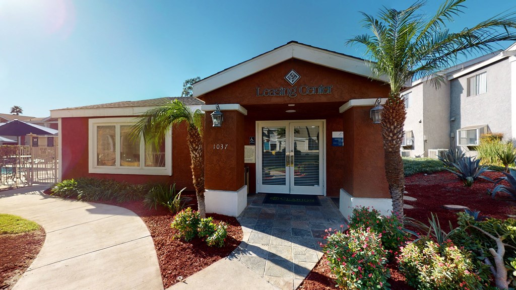 Apartments Ontario - Rancho Vista - Leasing Center Exterior With Decorative Trees, Bushes, and a Paved Walkway at Rancho Vista Townhomes, Ontario