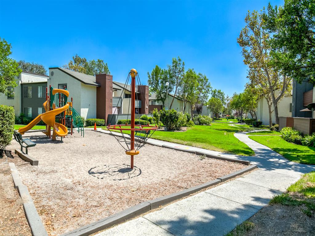  Playground with Playground Equipment, Sand, Bench Seating, Surrounded by Lush Landscaping and Avante Apartment Buildings at Avante Apartments, Ontario, California