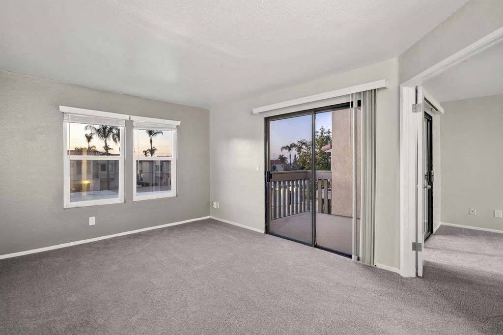 a bedroom with a sliding glass door and a balcony at Aspire Corona, Corona California