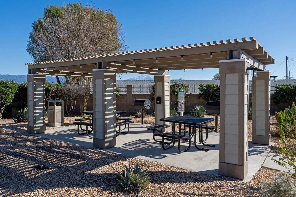 a picnic area with a table and benches under a pergola at Aspire Rialto, Rialto, 92376