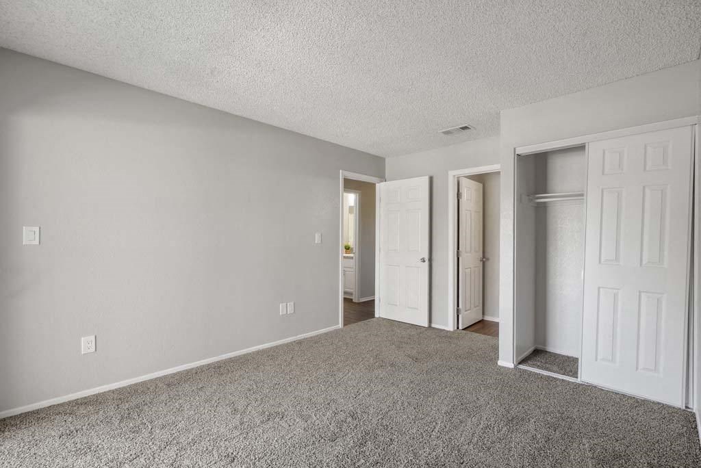 a bedroom with two doors and a carpeted floor at Aspire Redlands, Redlands, 92374