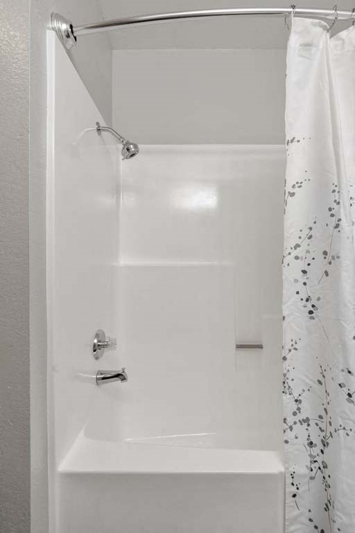 a white bath tub sitting next to a shower curtain at Aspire Redlands, California, 92374
