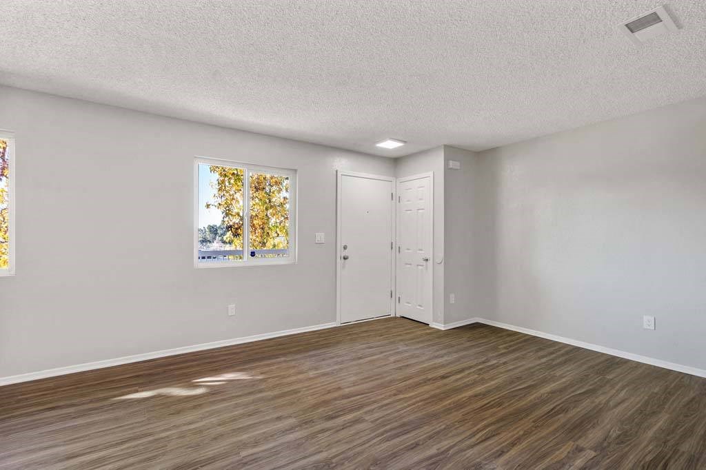 an empty bedroom with hardwood floors and a door to the bathroom at Aspire Redlands, Redlands, 92374