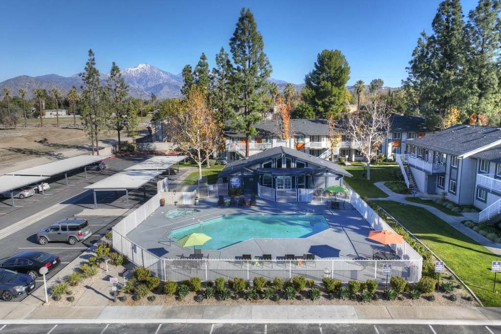 an aerial view of a resort style pool with a pool house in the background at Aspire Redlands, Redlands
