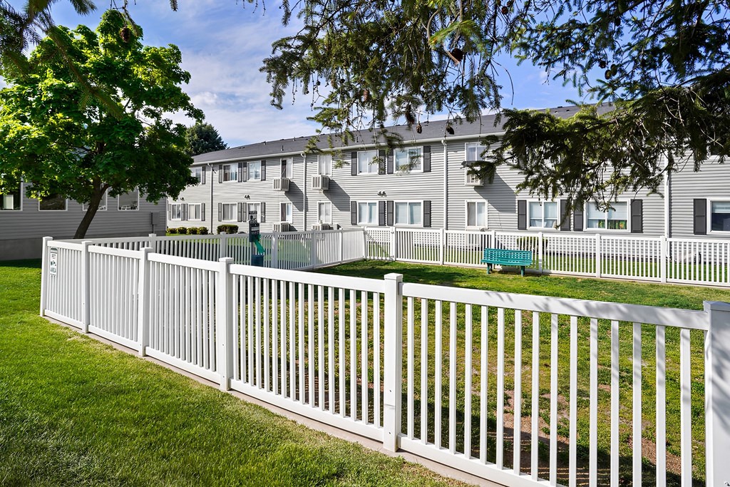 a white fence in front of an apartment building