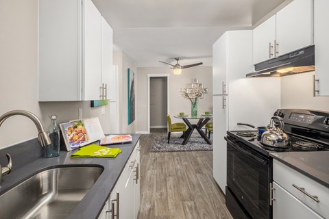 A modern kitchen with a stainless steel sink and black stove top.