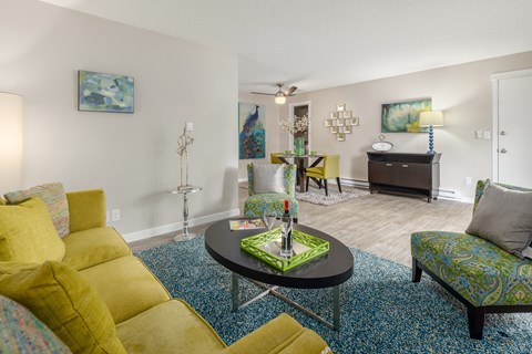 A living room with a yellow couch and a black coffee table.