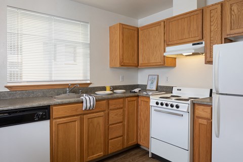 a kitchen with white appliances and wooden cabinets