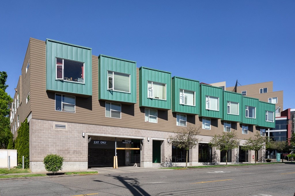a building with green and brown facade and a street