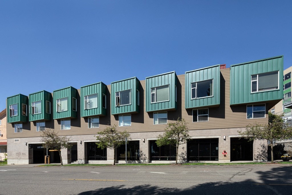 a building with green roofs on a city street