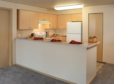 a white kitchen with a counter top and a refrigerator