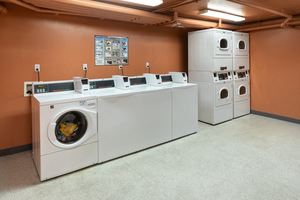 a row of washing machines and refrigerators in a laundry room