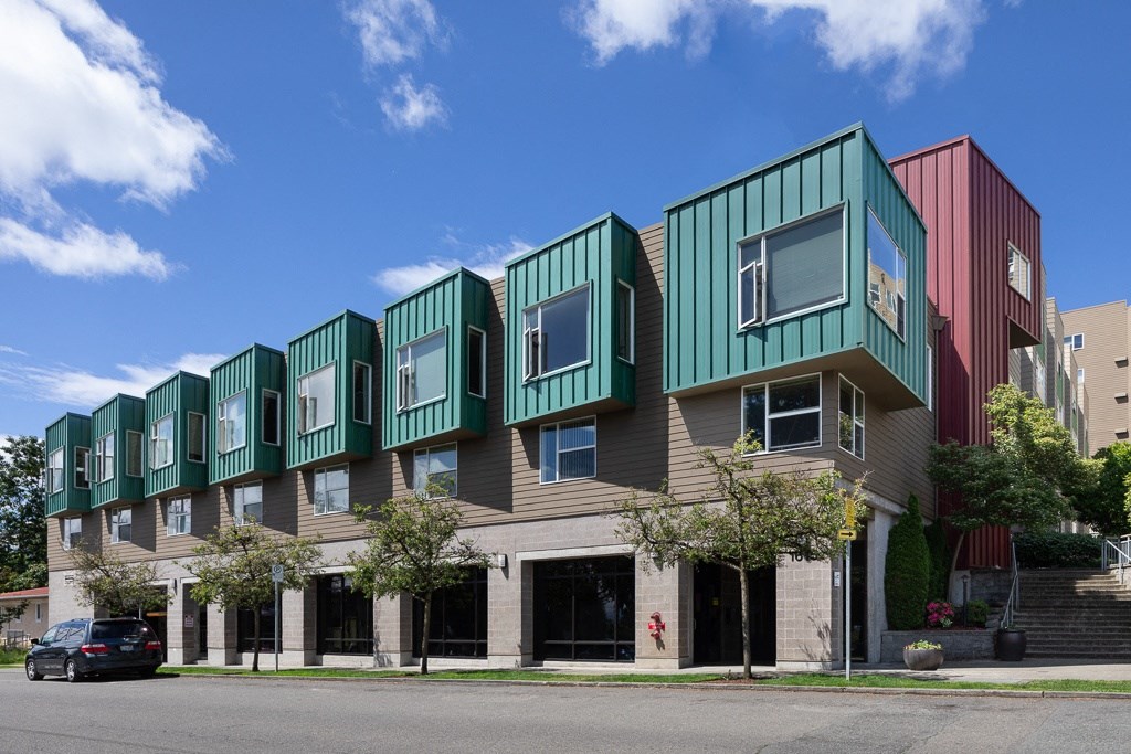 a row of green and red houses on a city street