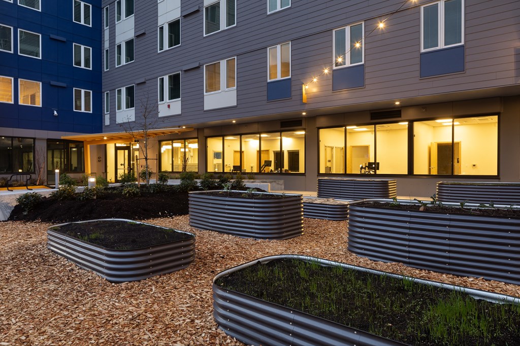 an outdoor courtyard of an apartment building with benches and grass