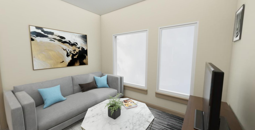 a living room with a gray couch and a white coffee table with blue pillows