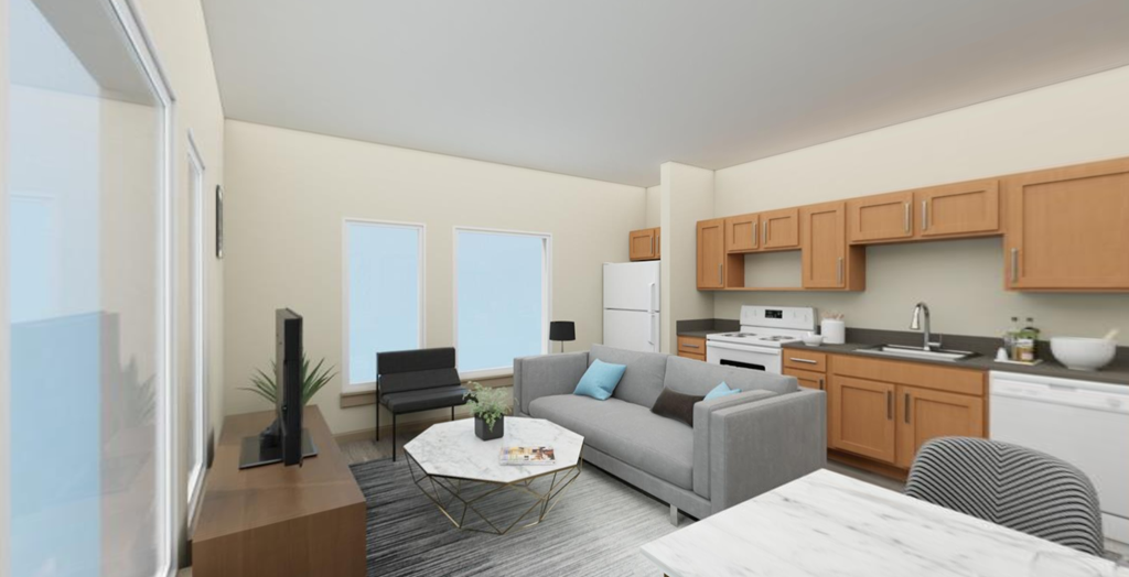 a living room with a couch and a coffee table in front of a kitchen with a sink