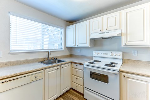 A kitchen with white appliances and cabinets.